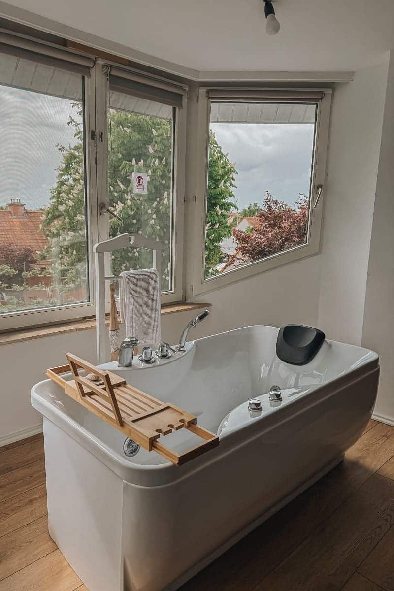 Baignoire balnéo en îlot face aux fenêtres dans la chambre Balnéo du Manoir Fleuri, gîte de groupe sur la Côte d'Opale